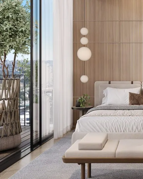 Bedroom with an upholstered bed, bench and floor-to-ceiling windows onto a balcony